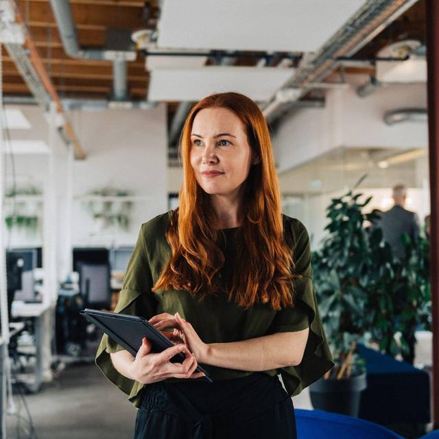 Eine Frau arbeitet mit einem tablet im Büro