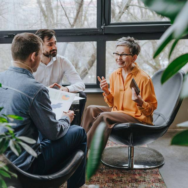 Frau im Gespärch mit ihren jüngeren Kollegen
