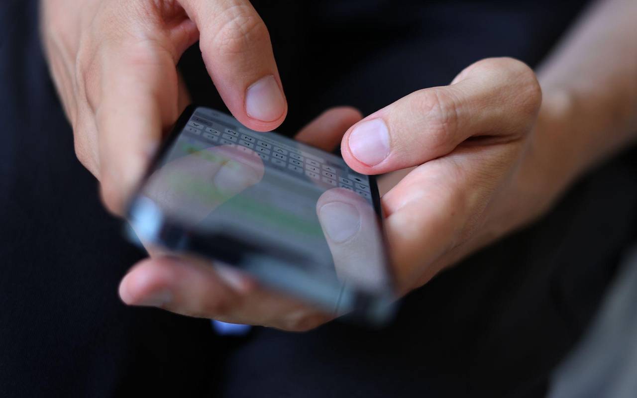 Mann tippt auf einem Smartphone eine WhatsApp Nachricht