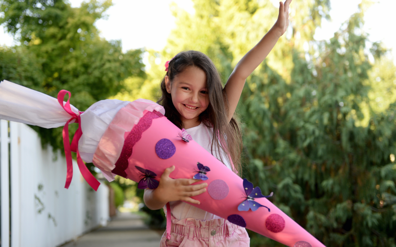 Glückliches Mädchen mit pinker Schultüte