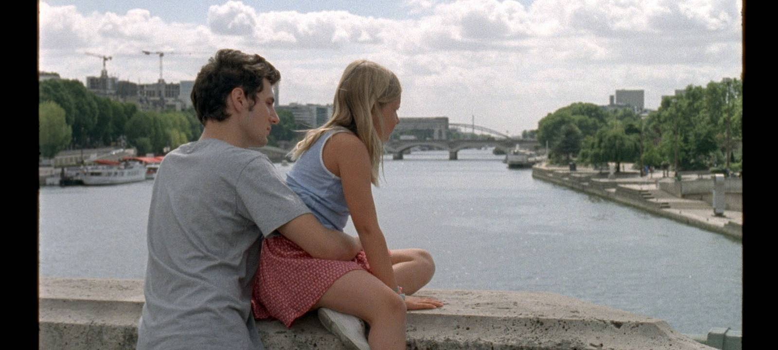 David sitzt mit seiner Nichte auf einer Brücke.