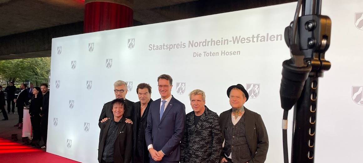 Die Toten Hosen und NRW-Ministerpräsident Hendrik Wüst auf dem rote Teppich. Die Toten Hosen bekommen den NRW-Staatspreis für ihr kulturelles Lebenswerk und für ihre sozialen Einsatz.