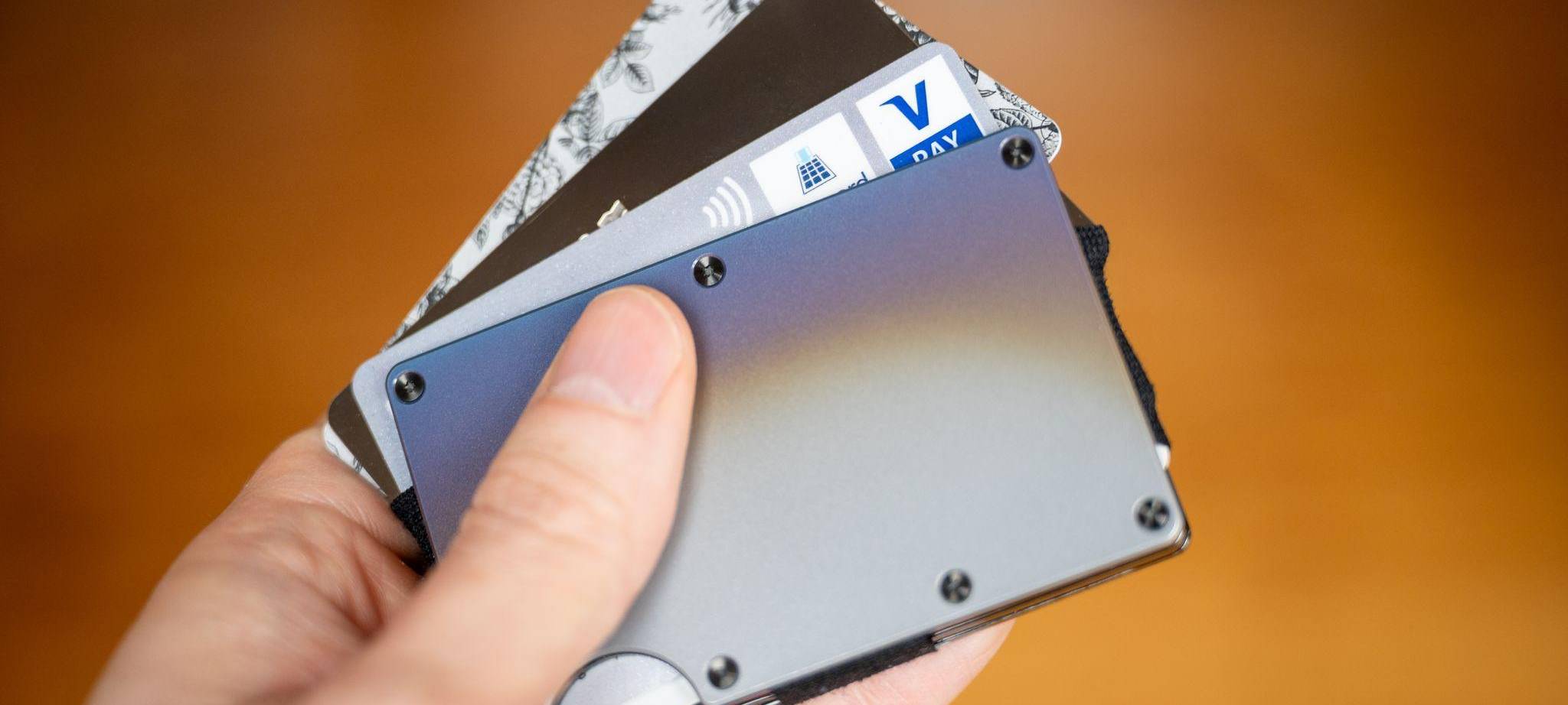 Ein Mann hält einen Cardholder mit verschiedenen Bezahlkarten