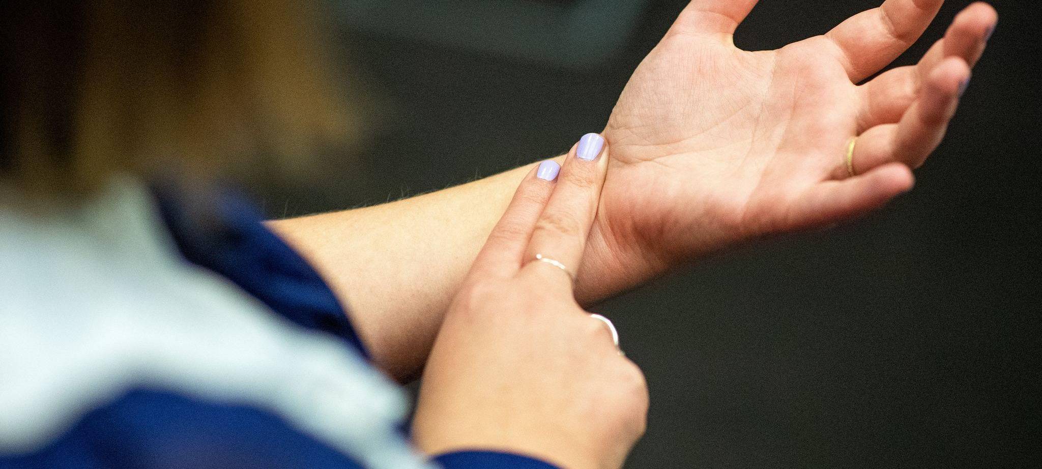 Eine Frau misst ihren Puls am Handgelenk