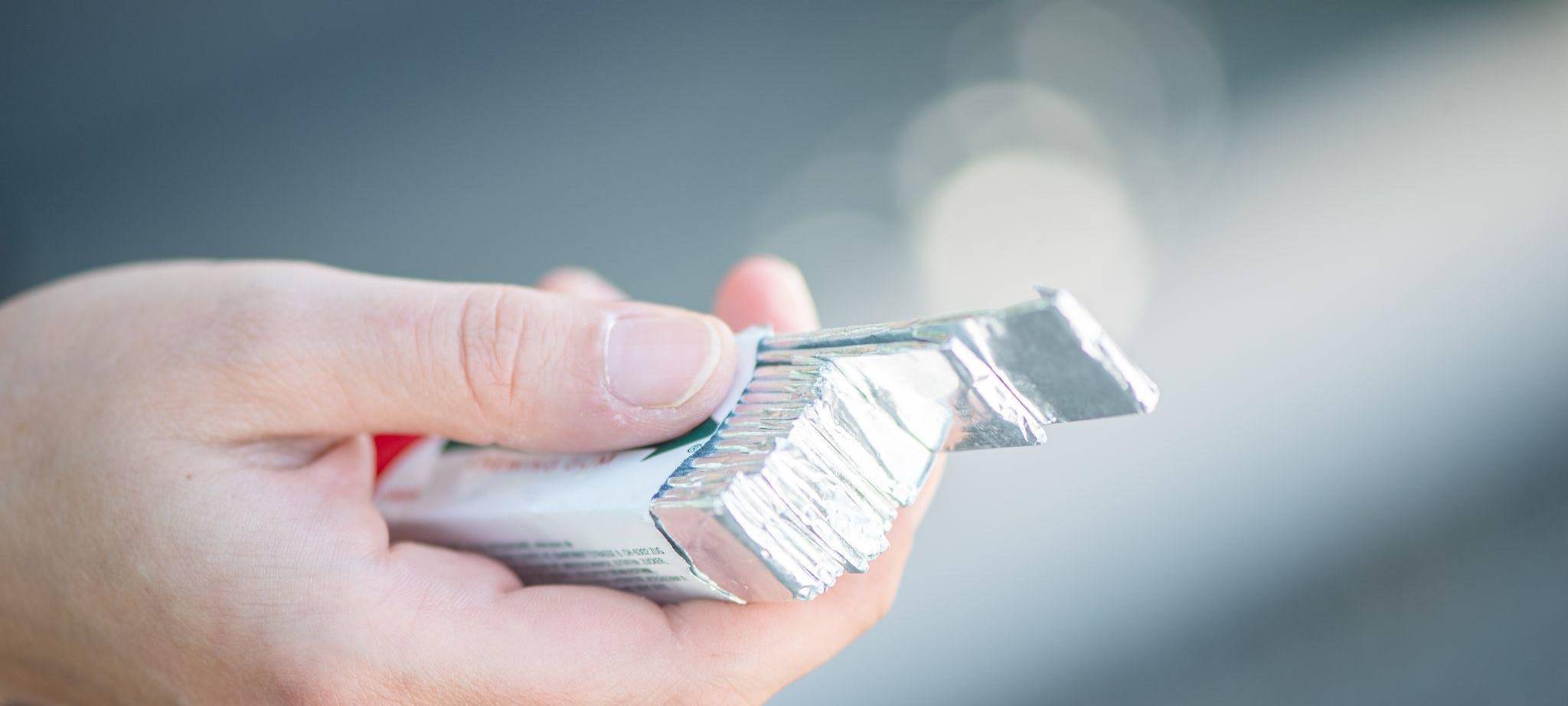 Eine Frau hält eine Packung Kaugummis in der Hand