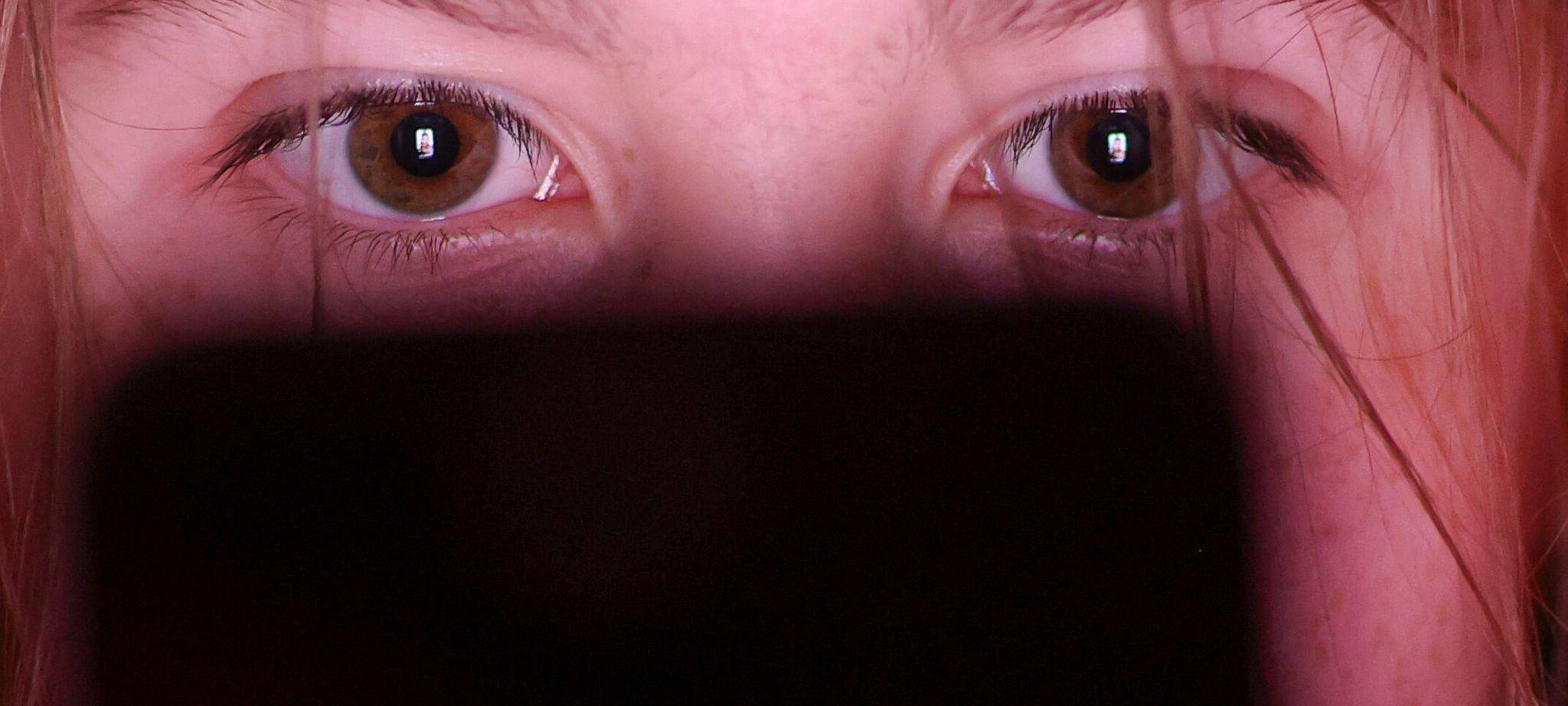Mädchen schaut auf ein Smartphone
