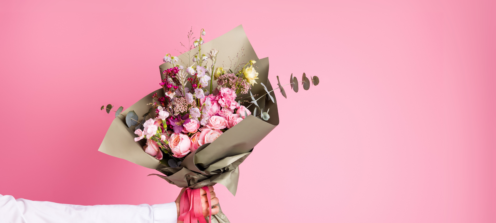 ein fröhlicher Blumenstrauß zum Valentinstag mit rosa Hintergrund